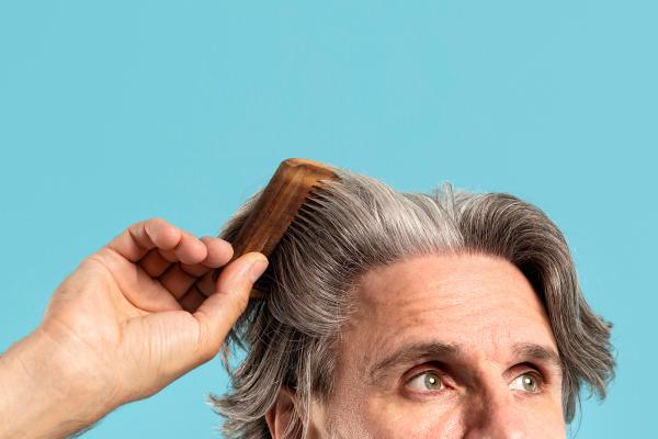 Evolución de implante capilar día a día - Hombre peinando su cabello natural luego del injerto capilar, el cual ha crecido de manera saludable y abundante gracias a los alimentos que consume