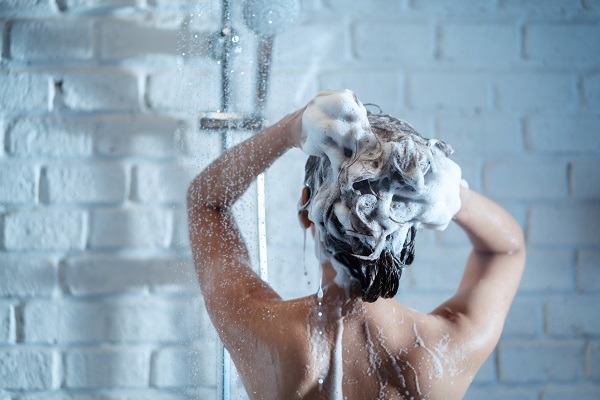 Champús para hacer crecer el pelo - Mujer lavando su cabello con un champú que estimula el crecimiento, el cual nutre y fortalece las hebras capilares