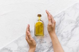 Hidratación del pelo - Imagen referencial de un recipiente con aceite hidratante para el cabello, el cual ayuda a nutrir y humedecer las hebras capilares