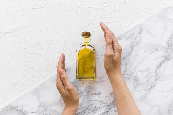 Hidratación del pelo - Imagen referencial de un recipiente con aceite hidratante para el cabello, el cual ayuda a nutrir y humedecer las hebras capilares