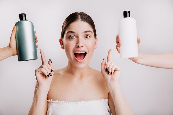 Hidratar el pelo en casa - Mujer decidiendo entre diferentes productos capilares que ayudan a hidratar el cabello, los cuales se pueden sustituir por ingredientes caseros