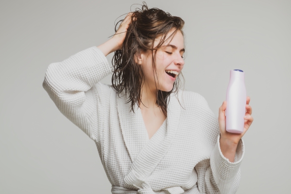 Hidratación del pelo - Mujer feliz luego de utilizar un champú hidratante para el pelo, el cual ayuda a mantener la suavidad y el brillo del cabello