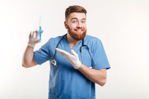 Anestesia en el injerto capilar - Médico sosteniendo en su mano una inyectadora con anestesia para realizar un tratamiento capilar