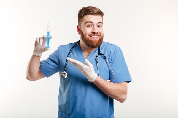 Anestesia en el injerto capilar - Médico sosteniendo en su mano una inyectadora con anestesia para realizar un tratamiento capilar