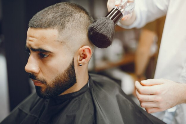 Trasplante capilar 3 meses después - Hombre cortando su cabello con un barbero profesional, para no ocasionar daños a los folículos pilosos que aún se encuentran fijándose en el cuero cabelludo