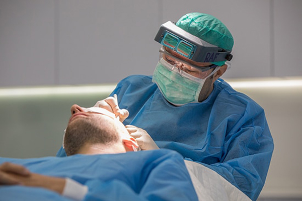 Injerto capilar sin rapar la cabeza - Médico especialista realizando un implante de cabello a un paciente masculino, el cual permite recuperar la densidad capilar sin rapar toda la cabeza