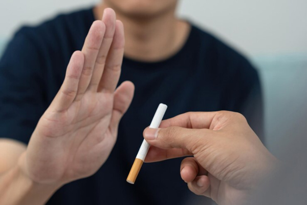 Implante capilar infectado - Hombre levanta la mano en señal de rechazo frente al ofrecimiento de un cigarrillo que podría entorpecer su proceso de cicatrización