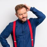 Pica la cabeza - hombre con camisa azul y tirantes rojos rascándose la cabeza
