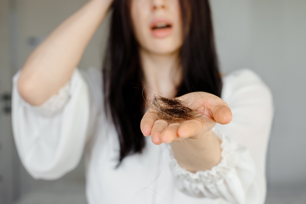 Joven se muestra sorprendida ante el desprendimiento de un gran mechón de cabello tras peinarse 
