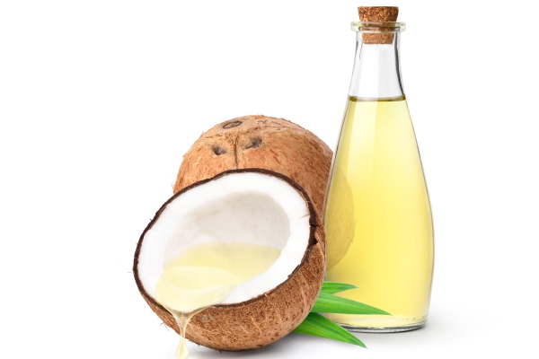 Aceite de coco en el pelo - frasco de aceite de coco al lado de un coco y de medio coco con aceite de coco en su interior
