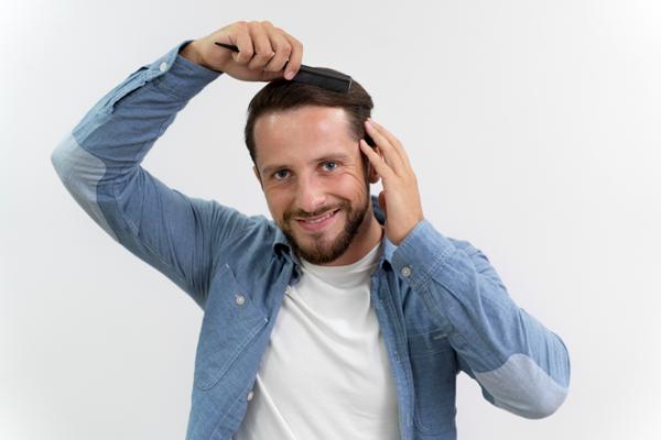Hombre peinando su pelo de manera suave, para no estimular la producción excesiva de sebo