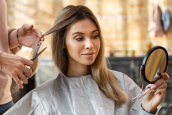Corte de pelo en la mujer - Estilista haciendo un corte de cabello a una mujer de rostro ovalado, para hacerla lucir más atractiva