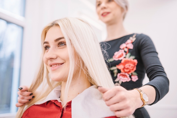 Corte de pelo en la mujer - Estilista arreglando el cabello de una mujer con rostro redondo, a la cual le favorece un corte largo