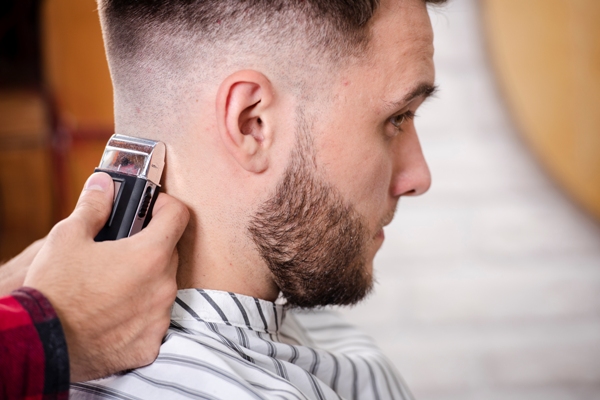 Cortes de pelo en el hombre - Estilista cortando el cabello de un cliente masculino, para crear un estilo moderno que lo haga lucir más atractivo
