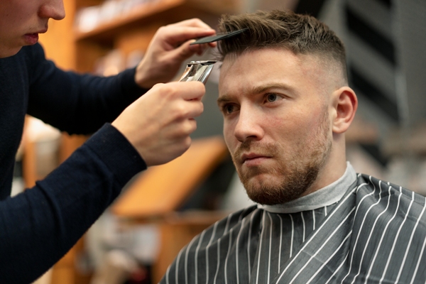 Cortes de pelo en el hombre - Estilista cortando el cabello de un hombre, para eliminar las puntas abiertas y hacerlo lucir más atractivo