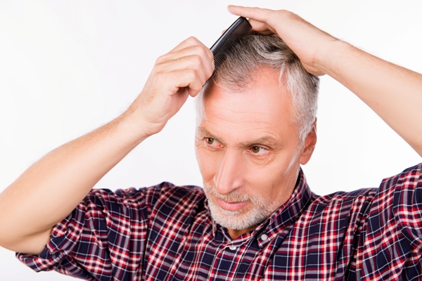 Hombre peinando su cabello de manera suave, para no ocasionar daño a los folículos pilosos