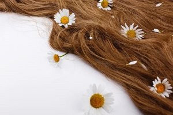 Kit para el cuidado del cabello - Imagen de un cabello liso junto a varias flores, en referencia a un pelo sano y perfumado