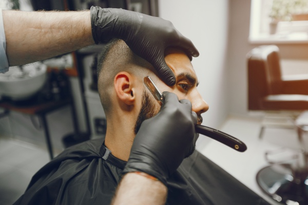 Barbero creando un estilo moderno a un caballero de rostro redondo, suavizando sus facciones para hacerlo lucir más atractivo