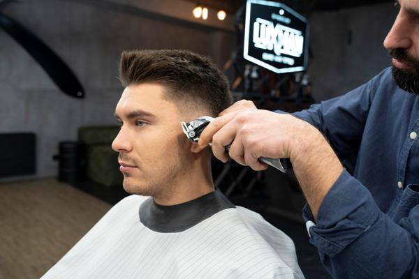 Cortes de pelo en el hombre - Barbero cortando el cabello de un cliente masculino, para crear un estilo acorde a sus rasgos faciales y hacerlo lucir más atractivo