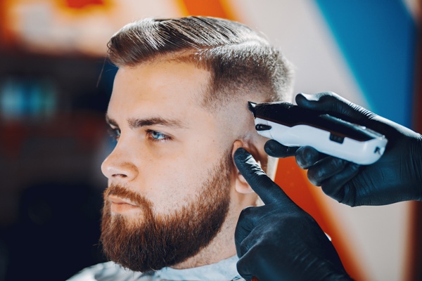 Cortes de pelo en el hombre - Barbero cortando el cabello de un hombre, para crear un estilo acorde a su cara que lo haga lucir más atractivo