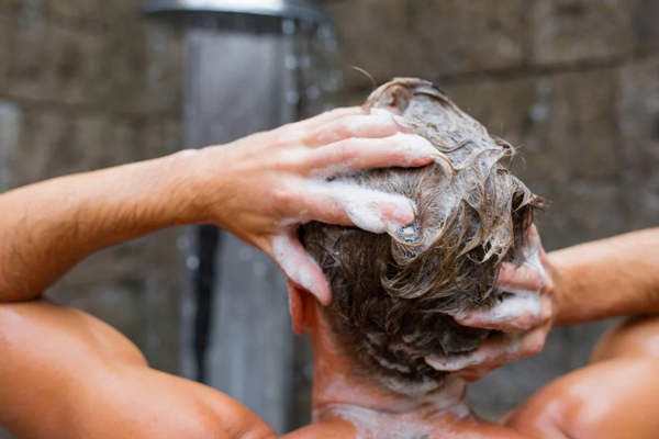 Cuidar el pelo en los hombres - Hombre lavando su cabello con un champú adecuado, para eliminar la suciedad y el exceso de grasa