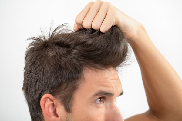 hombre tirando de su cabello con la mano