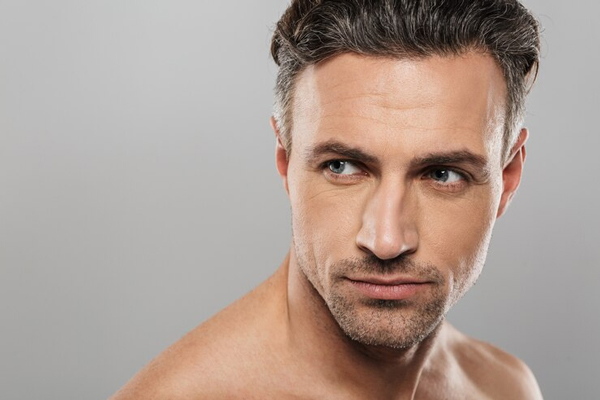 hombre adulto mirando a un lado mostrando un cabello con canas