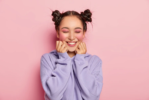 alopecia por tracción - imagen de una joven maquillada con un moño a cada lado de la cabeza