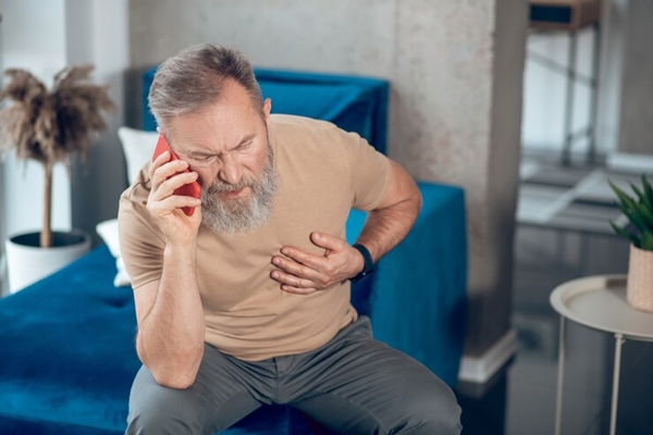 hombre mayor llamando a urgencias por un posible problema cardiaco