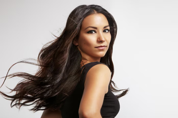 Agua de arroz para el pelo - Mujer morena cabello oscuro se muestra orgullosa por el brillo y la apariencia de su melena