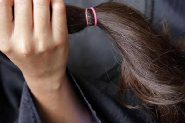 Donar pelo a otra persona - Mujer sostiene un mechón de pelo para donar en su mano