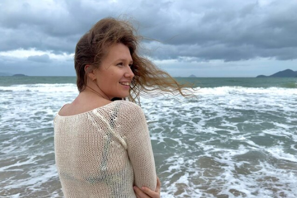 Revitalizar el pelo después del verano - Joven con bata disfruta de la calma a la orilla de la playa 