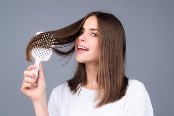 Biotina - Joven de pelo corto cepilla su melena lisa y fuerte con orgullo