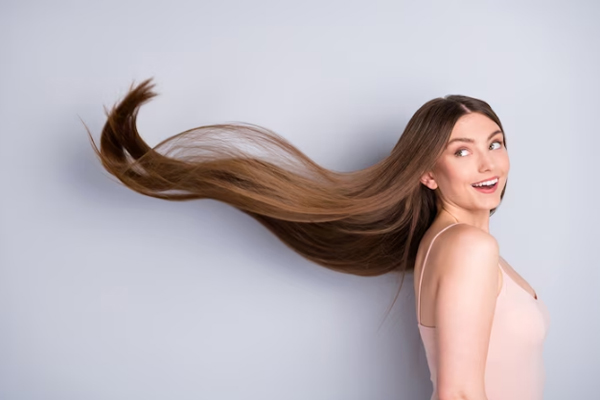 Champús para estimular el crecimiento del cabello - Mujer sonriente se muestra visiblemente orgullosa del largo de su melena