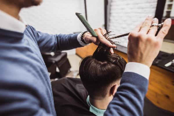 tips para hacer crecer el pelo, cortar puntas - Estilista realiza un corte favorecedor para resaltar la imagen de un cliente