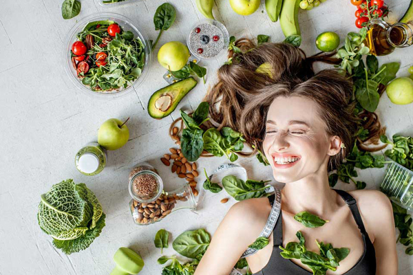 Superalimentos ideales para estimular el crecimiento del cabello rodean la cabeza de una joven sonriente