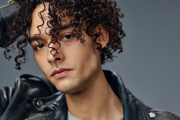 Cortes de pelo largo para hombre - Hombre moreno con chaqueta de cuero y estilo rockero seduce con sus definidos rizados