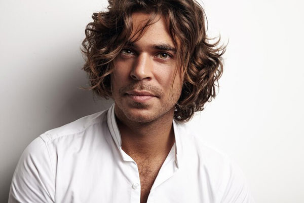Cortes de pelo largo para hombre - Caballero de ojos claros y piel bronceada con cabello largo en capas