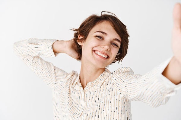 Cortes de pelo para cara redonda - Mujer se toma una foto visiblemente feliz con su nuevo corte de cabello