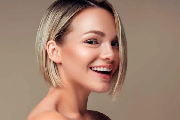 Chica sonriente de cabello teñido le apuesta a la nueva tendencia en materia de peinado