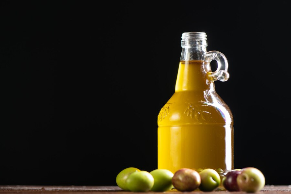aceite de oliva, aplicacion en el cabello - Jarra de vidrio con aceite extravirgen deja ver la calidad y la concentración del producto 