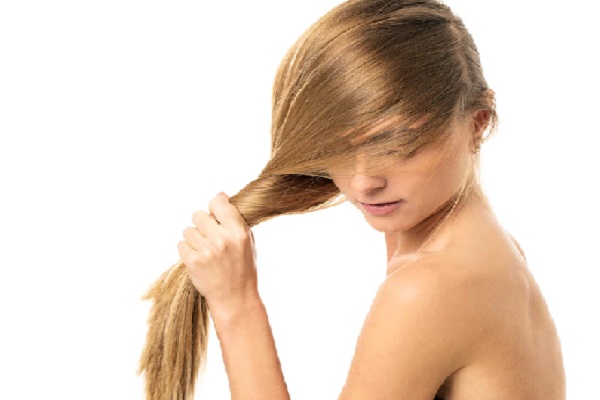 Botox capilar - Mujer haciendo una coleta con su cabello completamente liso y desenredado, gracias al tratamiento de botox para el pelo