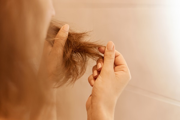 Pelo seco - Mujer tocando las puntas de su cabello, las cuales están abiertas y secas