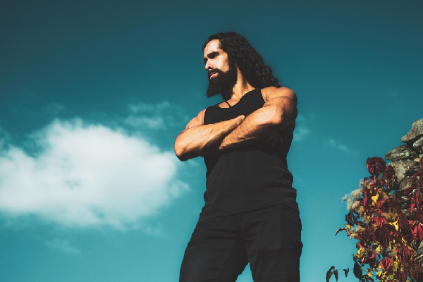 Cortes de pelo largo para hombre - Hombre barbado de estilo hipster viste todo de negro para salir a la calle