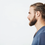 Los mejores cortes de pelo largo para hombre cortes de pelo largo para hombre - Chico de perfil lleva el cabello recogido para realzar su estilo