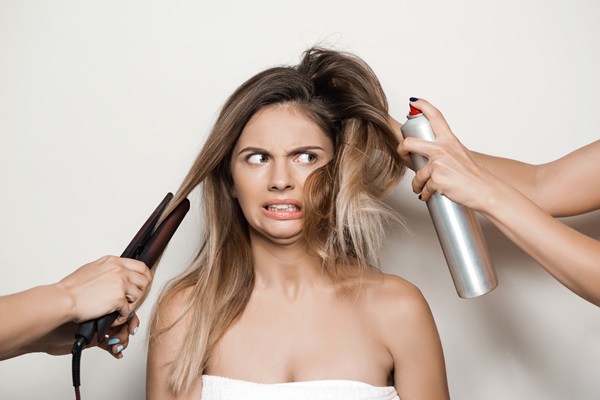 Mujer impactada por el daño que le ocasiona al pelo los químicos y herramientas de calor, como las planchas y secadores