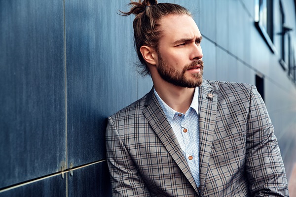 Peinados de hombre para bodas - Hombre de pelo largo con un peinado sostificado para el día de su boda, con una cola en la parte superior de la cabeza