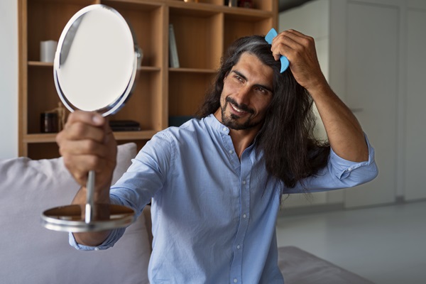 Masculino cepillando su cabello largo, para mantenerlo liso y arreglado los días previos al evento nupcial