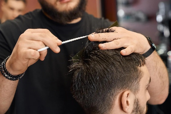 Peinados de hombre para bodas - Estilista cortando el cabello de un hombre, para realizarle un peinado elegante el día de su boda