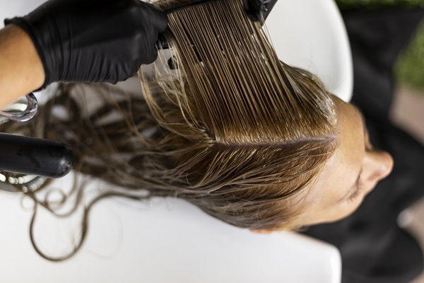 Botox capilar - Mujer en un salón de belleza donde le están haciendo un tratamiento de botox para el pelo